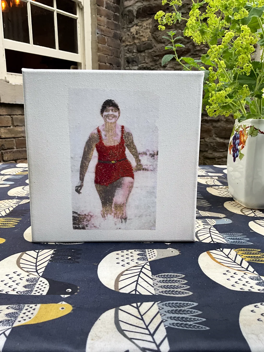 A stitched canvas based on a historic photograph of the swimmer Mercedes Gleitze emerging from the sea, the figure built from dense thread.