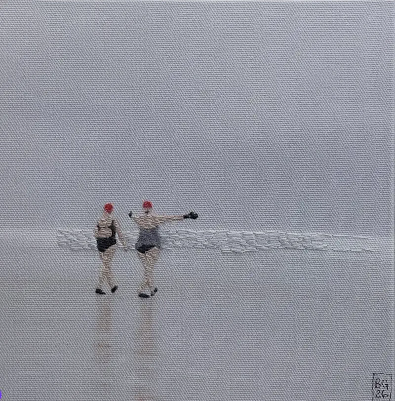 Two figures in red bathing caps walking across bare pale canvas, worked in thread, with a dense stitched line of surf running out behind them.